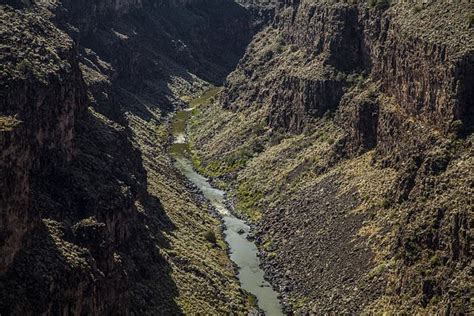 A River Flowing Through A Canyon Surrounded By Mountains