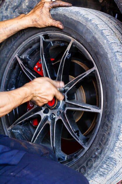 Premium Photo Car Mechanic Changing Tire On The Rim In Service Garage