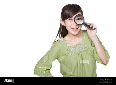 Portrait Of Young Woman Looking Through Magnifying Glass Stock Photo