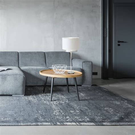 A Living Room With A Gray Couch And Wooden Table