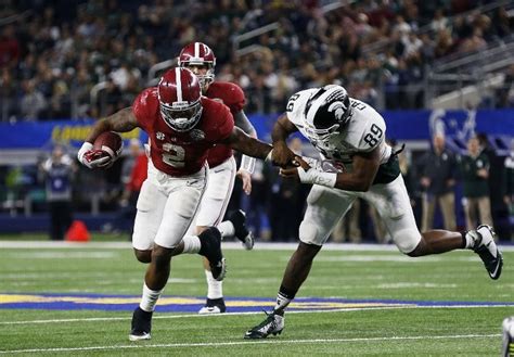 two football players running on the field during a game