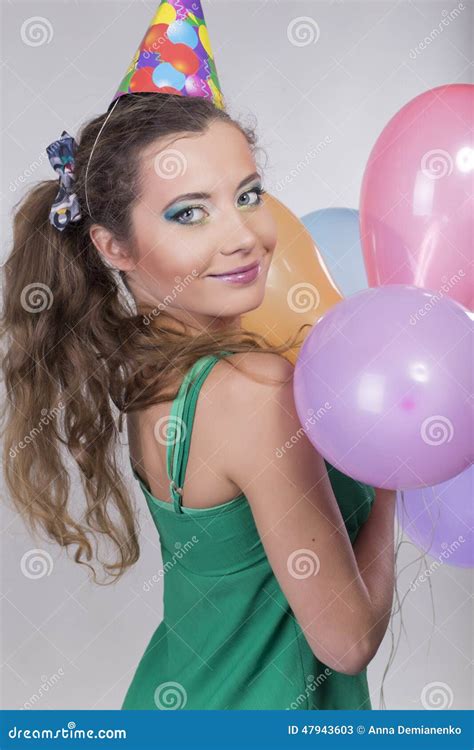 Brunette Woman In A Birthday Cap Holding Balloons And Smile Stock Image