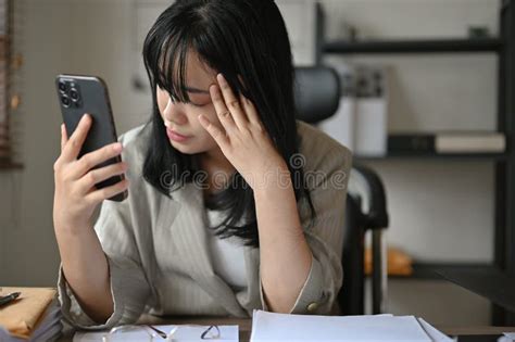 Stressed And Exhausted Asian Female Doctor At Her Office Desk Feeling