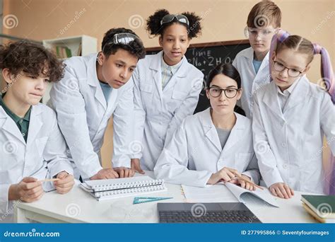 Group Of Teen Children Female Teacher In Science Class At School Stock