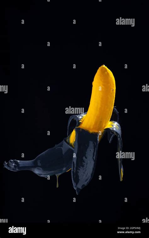 banana paint. Yellow-black painted banana on a black background ...