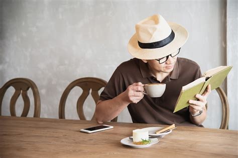 Homem Asi Tico Tomando Um Caf E Lendo Um Livro Foto Gr Tis