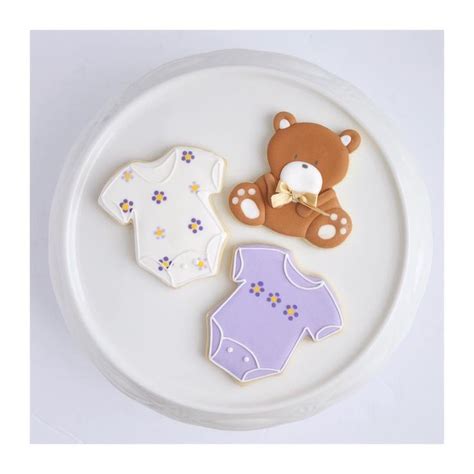 Three Decorated Cookies On A White Plate With A Teddy Bear And Oneshirt