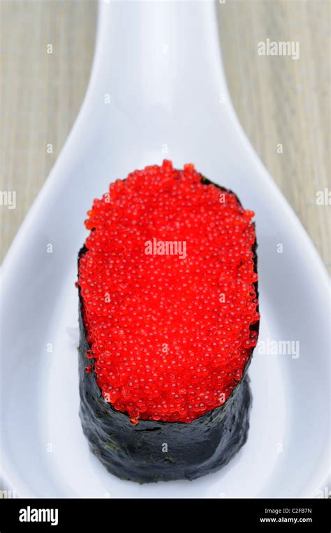 Brightly Colored Red Tobiko Flying Fish Roe Eggs On A Sushi Roll