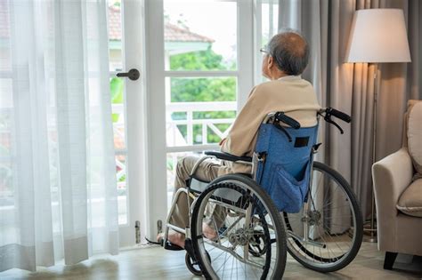 Un anciano asiático discapacitado sentado solo en silla de ruedas