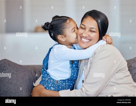 Adorable Little Mixed Race Girl Kissing Her Mom On Cheek While Bonding At Home Loving Caring