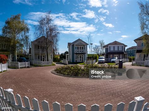 Suburbs Row Of Houses Under Blue Sky And Puffy Clouds Stock Photo