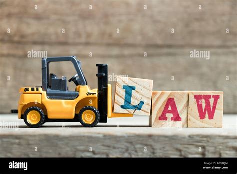 Toy Yellow Forklift Hold Letter Block L To Complete Word Law On Wood