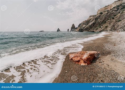 Large Red Jasper Rock On The Beach With The Sea In The Background Big