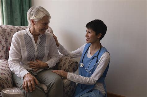 Premium Photo Female Doctor Interacting With Senior Woman In Living Room