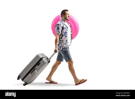 Man Pulling A Suitcase Smiling And Carrying A Swimming Ring Isolated On