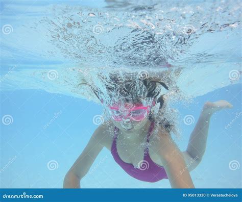 Une Natation Heureuse De Petite Fille Dans Une Piscine Photo Stock