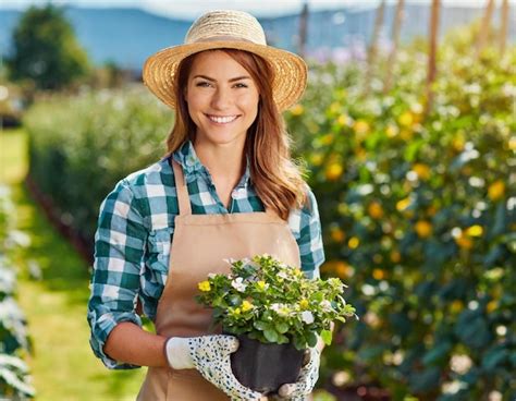 Premium Photo Woman Gardener Blonde Smiling With Flowers In The Garden