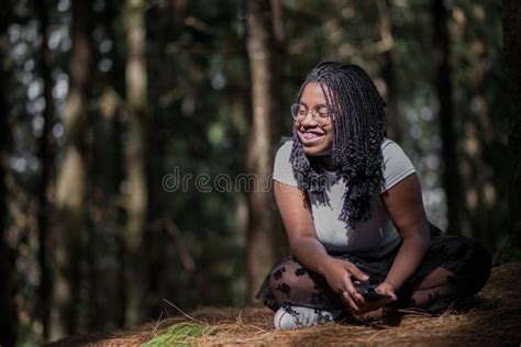 African American Woman Sitting On The Grass In A Forest Laughing Stock