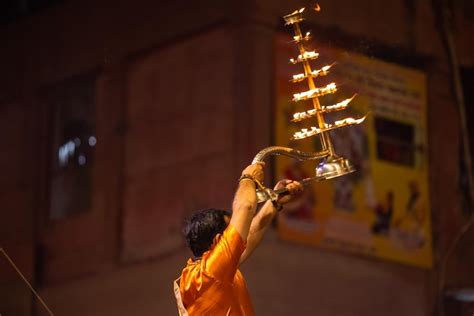 Premium Photo | Ganga aarti Portrait of young priest performing holy river ganges evening aarti ...