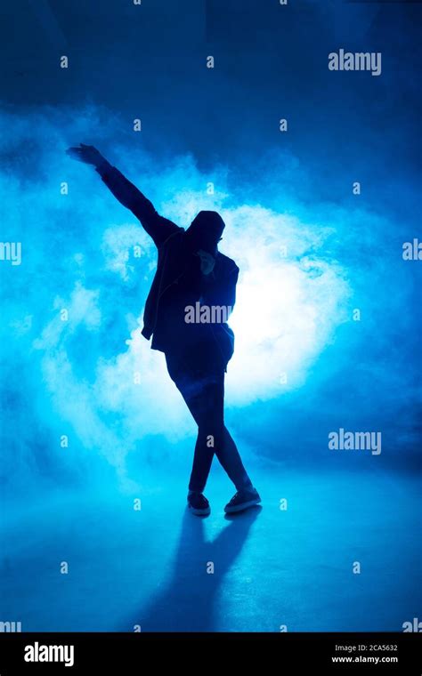 Full-size of silhouette of male break dancer performing on blue neon ...