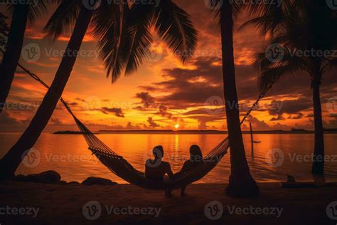 Tropical Island Sunset With Silhouettes Of Palm Trees And A Couple