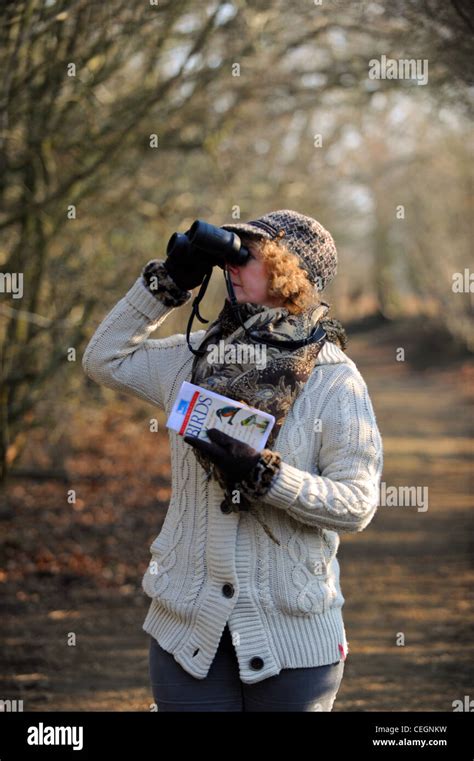 Female Birdwatcher With Binoculars And Identification Book At The Rspb