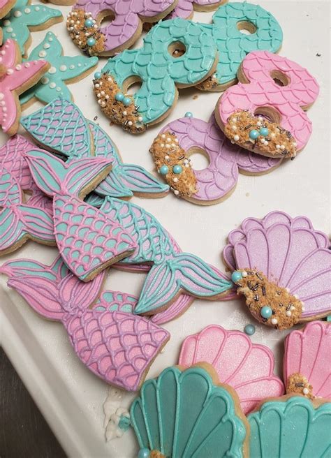 Some Decorated Cookies Are Sitting On A Table With Mermaid Tail And