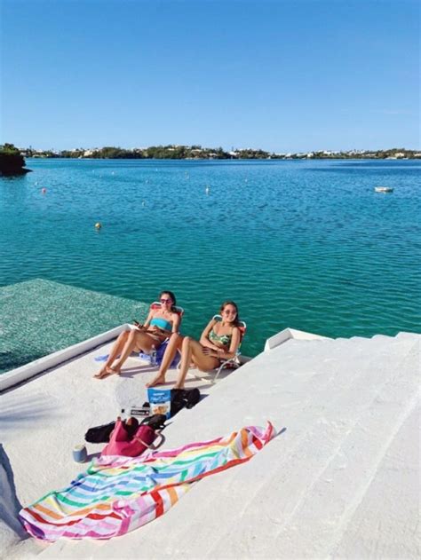 Three Women Sitting On The Edge Of A Dock