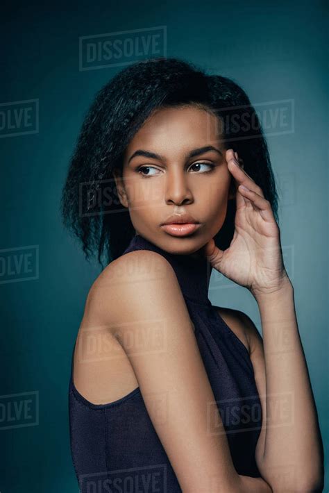 Attractive African American Girl Posing For Fashion Shoot On Dark Blue