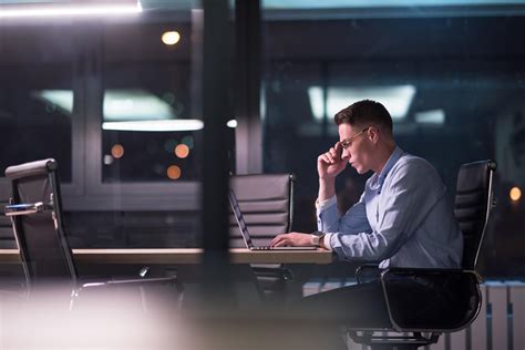 man working on laptop in dark office 12434762 Stock Photo at Vecteezy