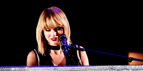 a woman standing in front of a microphone on top of a stage at a concert