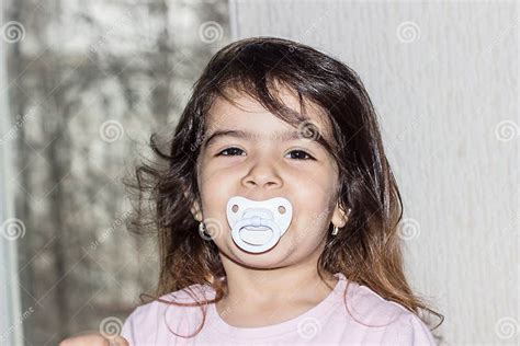 Close Up Portrait Of Four Year Old Girl Baby Holding A Pacifier In