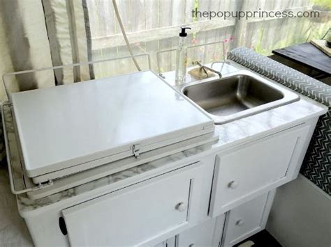 A Kitchen Sink And Cabinets In Front Of A Window