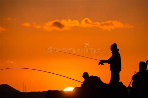 Fisherman In Silhouette On A Fresh Water Lake During Stunning Sunset