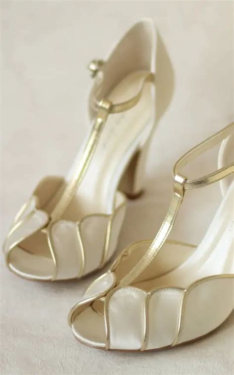 A Pair Of White High Heeled Shoes Sitting On Top Of A White Tablecloth