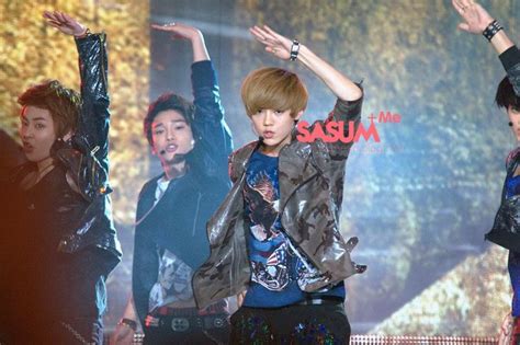 The Boy Band Beast Perform On Stage At An Event With Their Arms In The Air