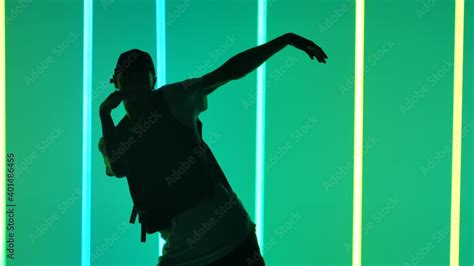 Young Man Dancing Hip Hop Against The Background Of Bright Neon Lights