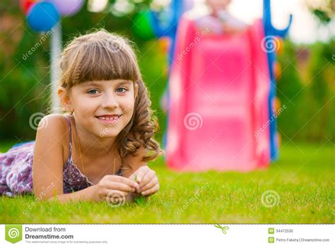 Jolie Fille Se Trouvant Sur L Herbe Au Terrain De Jeu Photo Stock