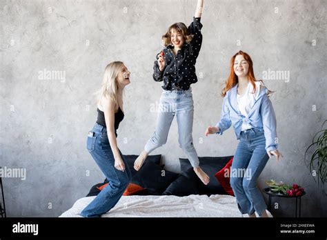 Three Young Adult Girlfriends Dressed Casual Having Fun Jumping