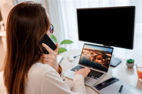 Empresária trabalhando em home office no laptop e falando ao telefone