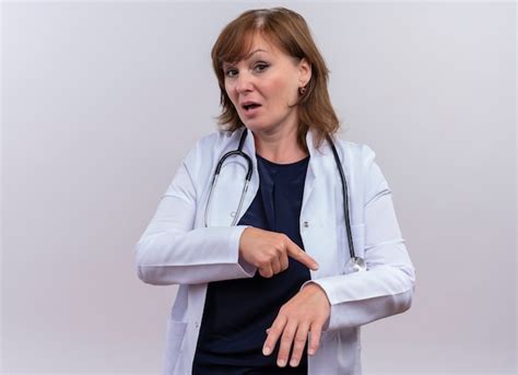 Doctora de mediana edad vistiendo bata médica y estetoscopio apuntando