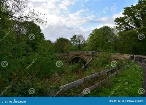 Rural Stone Arched Bridge Over A Small Stream In England Stock Photo