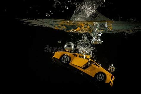 Yellow Miniature Car Dropped Splashing And Sinking On Water Stock Image