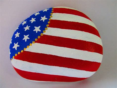 A Painted Rock With An American Flag Design On Its Side And Gold Trim