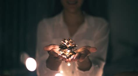 Premium Photo Midsection Of Woman Holding Illuminated Pine Cone In