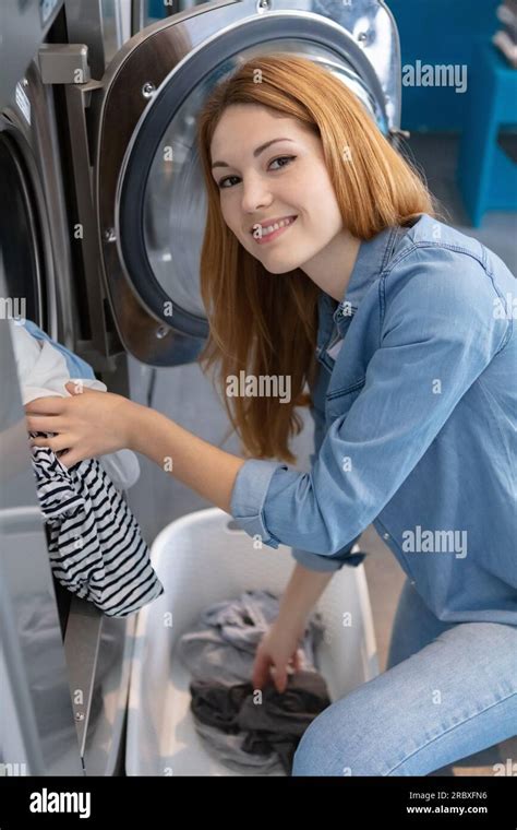 Woman Doing Laundry Reaching Inside Washing Machine Stock Photo Alamy