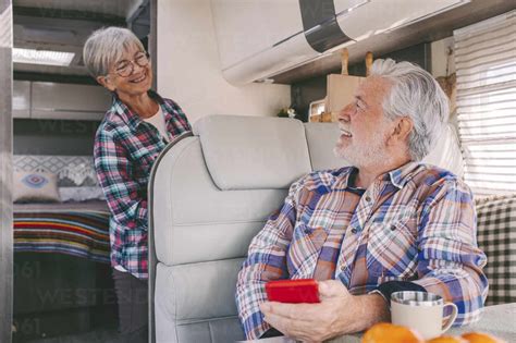 Lächelnder älterer Mann im Gespräch mit Frau im Wohnmobil lizenzfreies