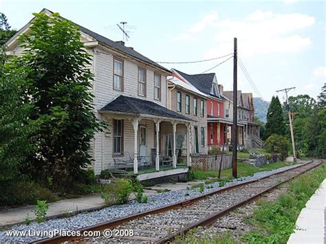 an old train track runs past two houses on the other side of the railroad tracks