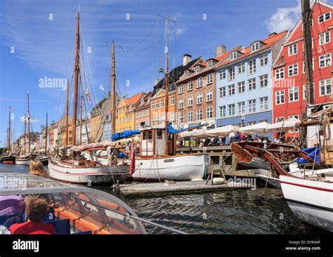 Tourists on Copenhagen canal tour boat with old wooden boats moored in ...