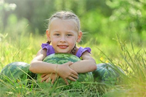 Premium Photo Small Girl With Watermelons On Lawn